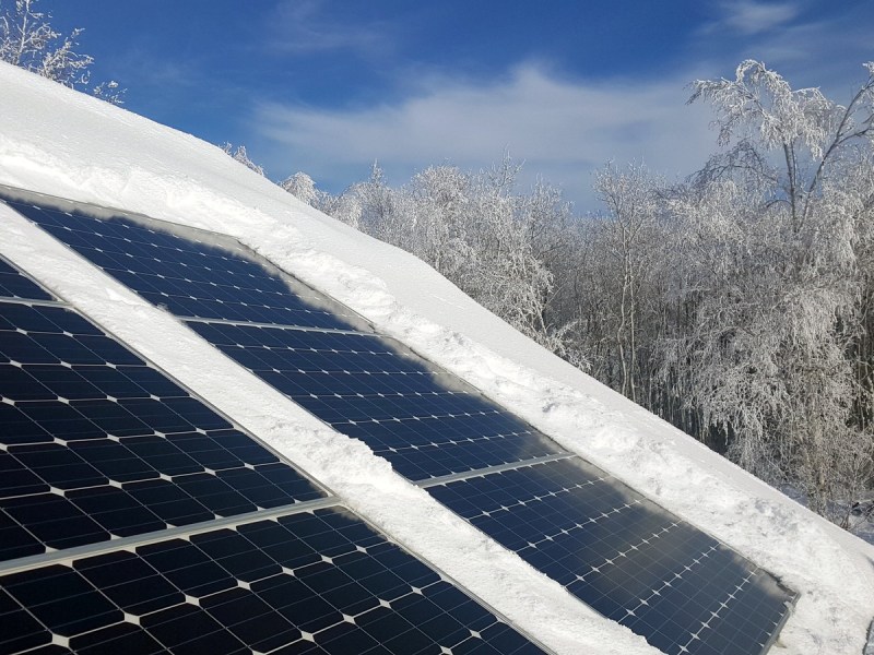 Snow atop a row of solar panels.