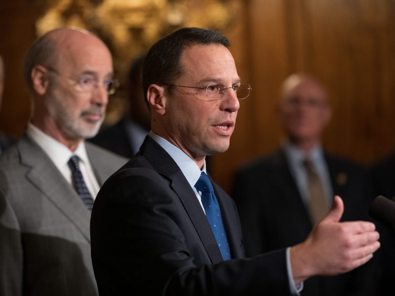 Pennsylvania Attorney General Josh Shapiro stands in front of state Gov. Tom Wolf.