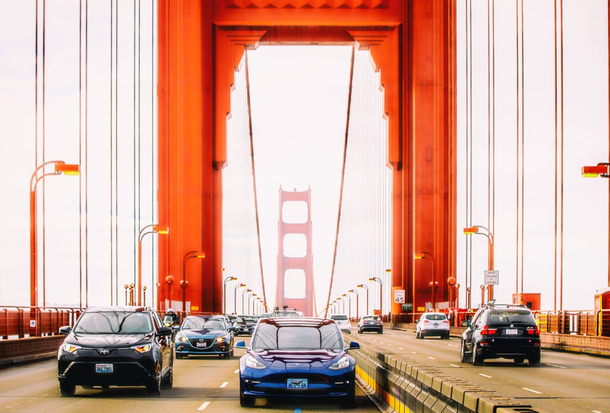 A Tesla and other cars drive across the Golden Gate bridge
