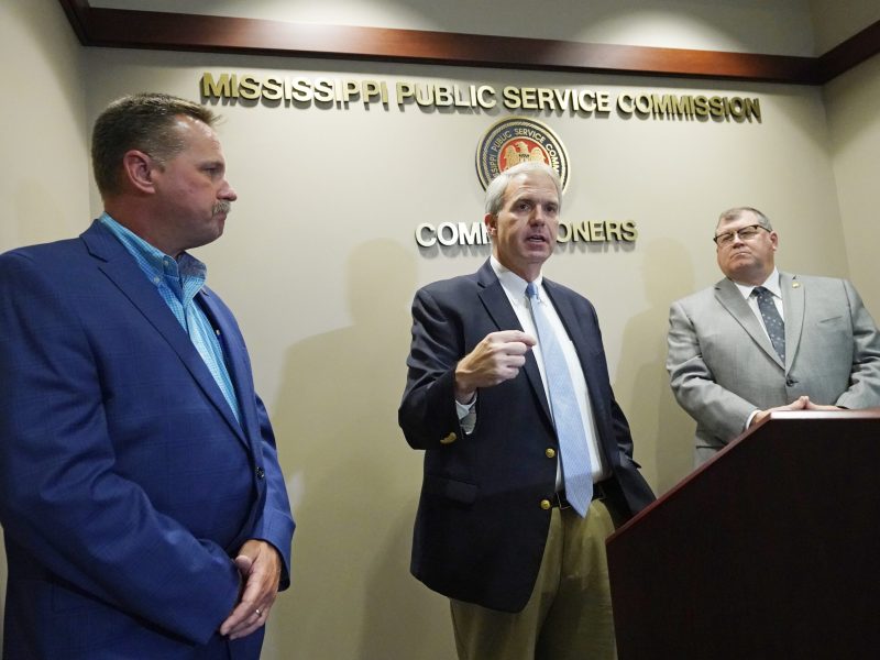 Mississippi Public Service Commissioner Brandon Presley, center, speaks at a press conference in June 2022, along with Commissioners Brent Bailey, left, and Dane Maxwell. All three are White men.