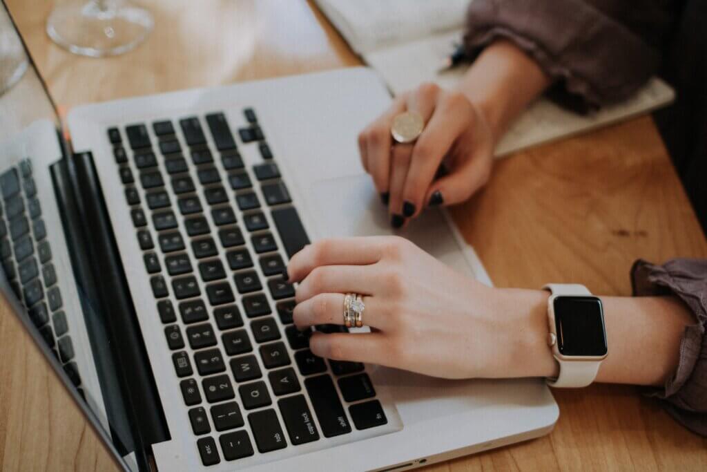 hands typing on laptop, maybe sending a Giving Tuesday email