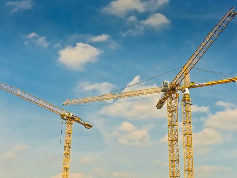 A trio of cranes tower over a construction site.