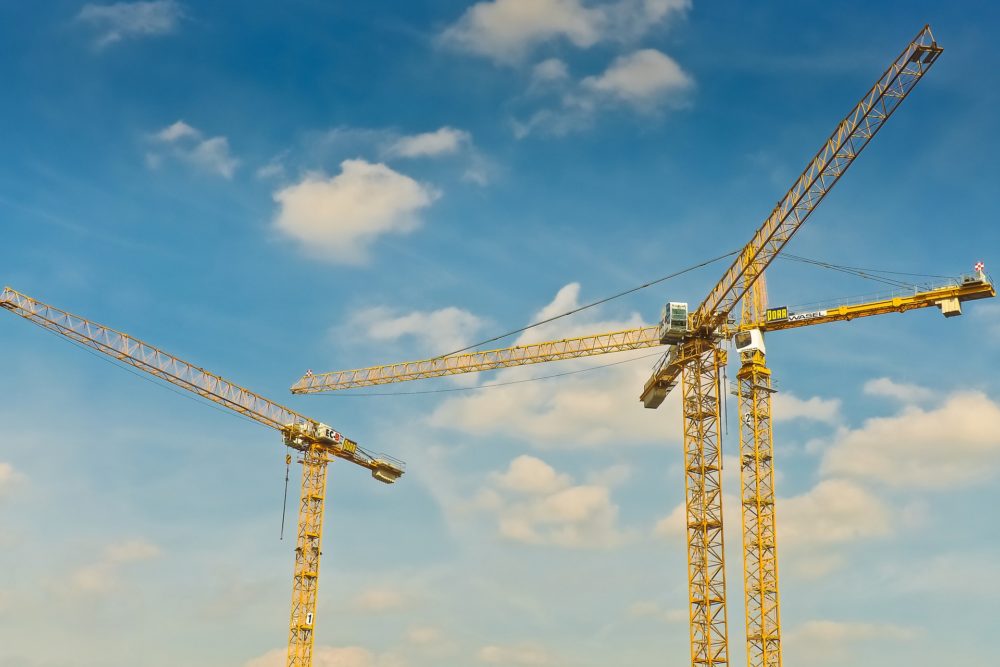 A trio of cranes tower over a construction site.