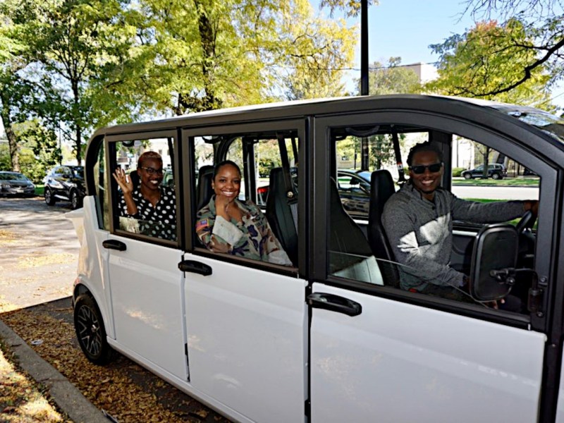 GEST owners pose in an electric shuttle vehicle
