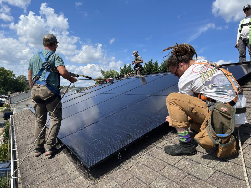 The SunDay Solar crew installs panels on Rachel Brown's roof.