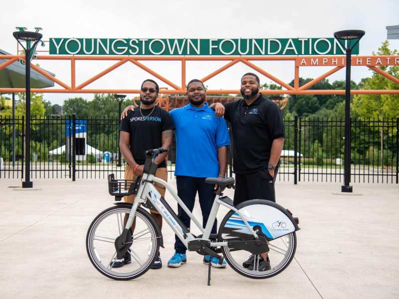 Kent Wallace, Paris Wallace, and Ronnell Elkins pose with a YoGo electric bike in Youngstown.